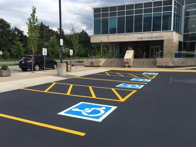 Sealcoated parking lot with symmetric parking yellow lines and ADA services